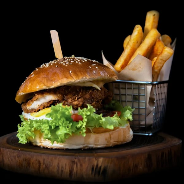 Crispy chicken burger with lettuce, tomato, and a side of golden french fries.